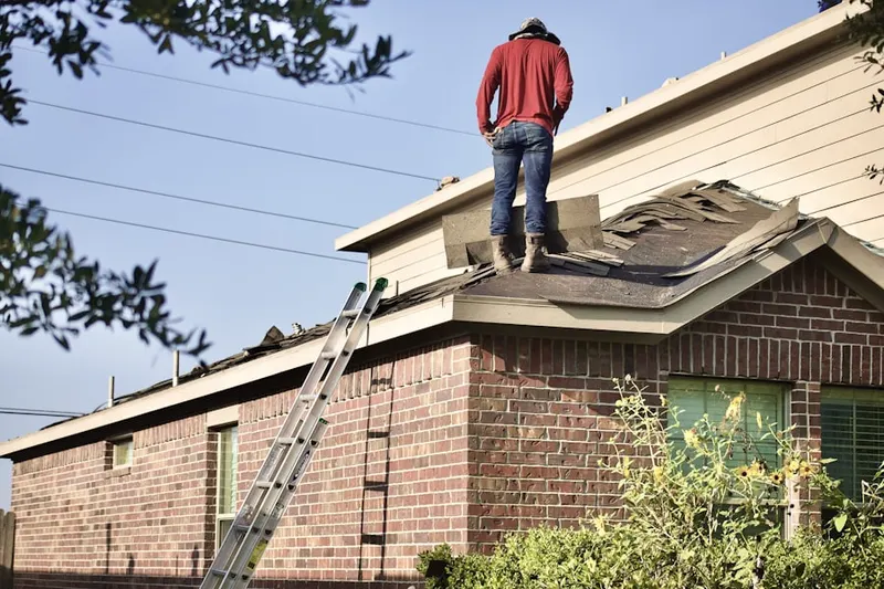 Professional roofer working on a residential roof in North Woburn